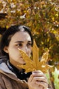 Autumn woman. Fall season concept. A portrait of pretty female with an yellow autumn leaf
