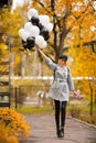 Autumn woman in autumn park with balloons. Fashion girl in gray coat