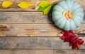 Autumn wooden background with yellow-red and green leaves and pumpkin. Composition on a natural table made of boards Royalty Free Stock Photo
