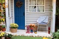 Autumn wooden porch home. Cozy Autumn terrace with chair, plaid, rubber boots, baskets with chrysanthemums and pumpkins. Decoratio Royalty Free Stock Photo