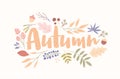 Autumn word handwritten with elegant cursive font decorated with fallen tree leaves, dried flowers, acorns, berries