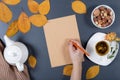 Autumn working desk. Yellow and orange leaves, white cup of herb