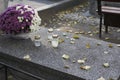 Autumn yellowed leaves on a terrazzo tombstone with chrysanthemums and candles.