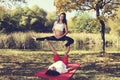 Autumn yoga in the park Man and pregnant woman doing acro yoga