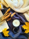 Autumnal composition with candles, sweater and book