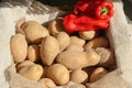 Autumnal concept with a sack full of fresh potatoes and red peppers Royalty Free Stock Photo