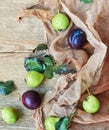 Autumnal flat empty design mockup with pears, leaves and plum on textured coral textile on wood