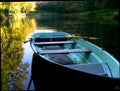 Lake with blue rowing boat and yellow reflection in the water