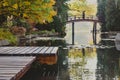 Autumnal japanese garden in a european city, wooden bridge and wooden platform, place for relax