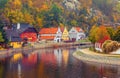 Autumnal landscape with coloured house over river