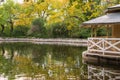 Autumnal landscape with little house on the edge of a pond, with reflections, horizontally Royalty Free Stock Photo