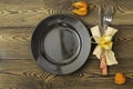 Autumnal table setting for Thanksgiving dinner. Empty plate, colored leaves on wooden table. Fall food concept. Royalty Free Stock Photo