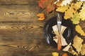 Autumnal table setting for Thanksgiving dinner. Empty plate, cutlery, colored leaves on wooden table. Fall food concept. Royalty Free Stock Photo
