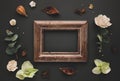 Autumnal-winter composition with vintage frame, dried leaves, bark of trees and berries on dark background. Flat lay, copy space