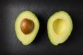 Avacado halves on dark background