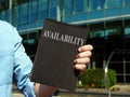 Availability. A man holding a notebook with the inscription. Royalty Free Stock Photo