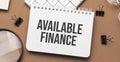 available finance on notepad with pen, glasses and calculator