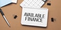 available finance on notepad with pen, glasses and calculator