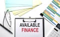 AVAILABLE FINANCE text on the paper sheet with chart,color paper and calculator