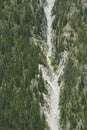 Avalanche track on steep mountainside above a road