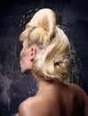 Avant-garde hairstyle with golden hair. Complex wave forms, decorations and rhinestones