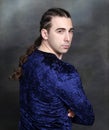 Attractive male model with braids posing in studio. Avantgarde, style, fashion concept.