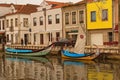 Typical landscape view of ancient city Aveiro. Moored colorful boat near embankment with small old houses