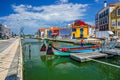 Aveiro cityscape with traditional colorful Moliceiro boat with tourists mooring in narrow water canal