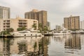 Urban Landscape in Aventura waterway with skies, water, boat, reflections and buildings