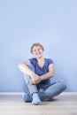 Average blond woman sitting on the floor cross-legged