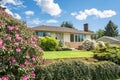 Average family house with rhododendron flowers in front
