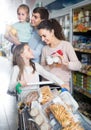 Parents with two little kids holding purchases in store Royalty Free Stock Photo