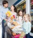 Satisfaction parents with two kids holding purchases in store Royalty Free Stock Photo