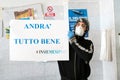 Avetrana, Italy, - Marth, 19, 2020. Italian fish seller with medical mask and gloves is holding a poster Andra tutto bene