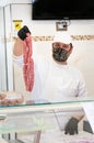 Avetrana, Italy, - Marth 21, 2020. Salesman is serving a costumer a meat, wearing handemade mask and gloves protection during