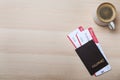Avia tickets, passport and cup of coffee on wooden table, flat lay with space for text. Travel agency concept