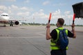 Aviation marshaller meets airplane at the airport. Airport worker. Modern airport. Aviation business. Travel by plane