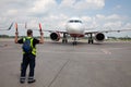 Aviation marshaller meets airplane at the airport. Airport worker. Modern airport. Aviation business. Travel by plane