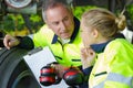 Aviation mechanic with female apprentice by aircraft landing gear