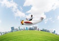 Aviator driving propeller plane above city Royalty Free Stock Photo