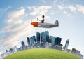 Aviator driving propeller plane above city Royalty Free Stock Photo