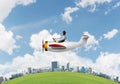 Aviator driving propeller plane above city Royalty Free Stock Photo