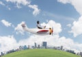 Aviator driving propeller plane above city Royalty Free Stock Photo