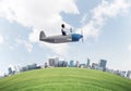 Aviator driving propeller plane above city Royalty Free Stock Photo