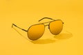 Aviator sunglasses on yellow background. Sunglass in sunlight for summer concept. Gold gradient on mirror lens aviator Royalty Free Stock Photo