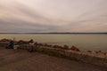 Avid fisherman fishing spot. Fishing tackle on a pier on the background of the lake Balaton. Vibrant sky in cloudy day.