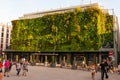 Green plants living facade of Less Halles with walking around people in Avignon, France during the Art Festival Off