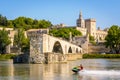 A man jet skiing on the Rhone river in front of the Saint-Benezet bridge and the Papal palace in Avignon, France