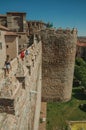 People on pathway over thick wall and Cathedral of Avila