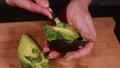 avocado artistry: woman hands cutting avocado on wooden board